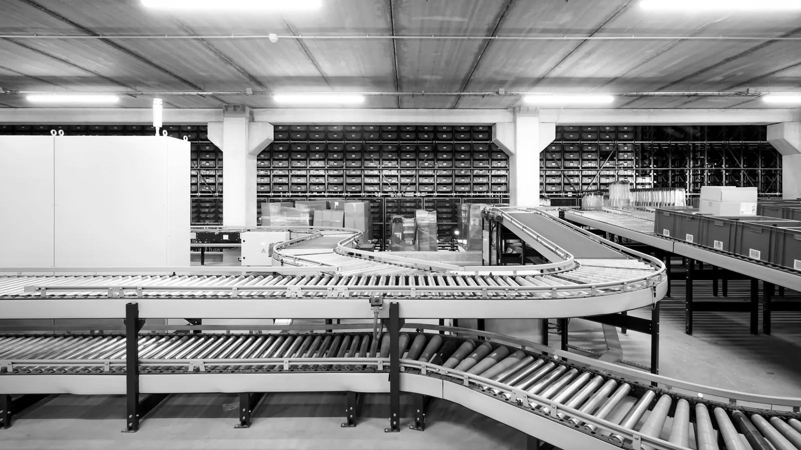Bandas transportadoras de rodillos en un centro de distribución, en blanco y negro